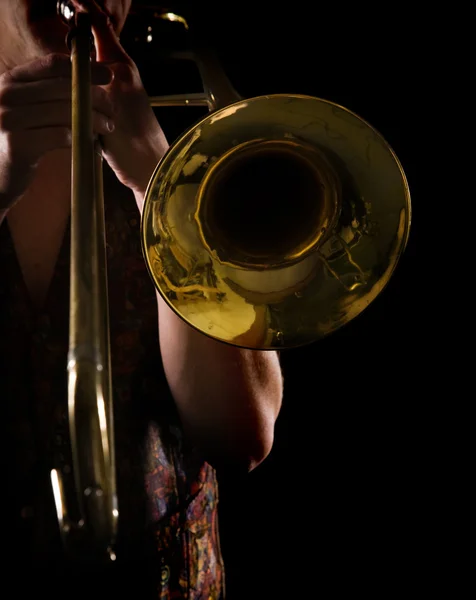Homme jouant un trombone, forte lumière latérale contrastée, version couleur — Photo