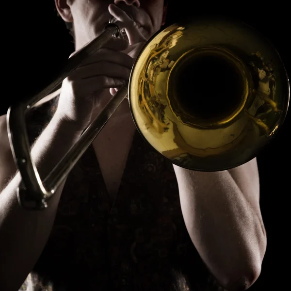 Muž hraje trombón; silné kontrastní boční světlo; barevné verze; — Stock fotografie