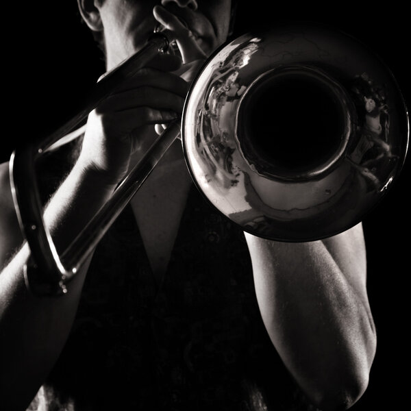 Hombre tocando un trombón; fuerte contrastante de luz lateral; versión monocromática ; — Foto de Stock