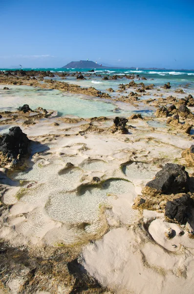 Fuerteventura, corralejo flagg-stranden, skarpa volcanc stenar reveale — Stockfoto
