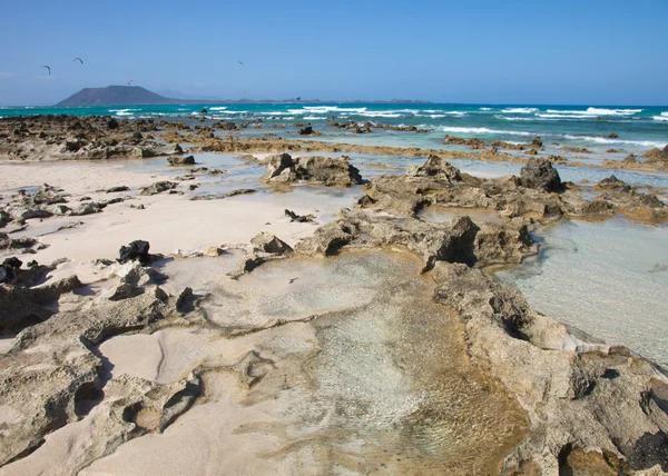 Fuerteventura, Playa Bandera de Corralejo, revelan afiladas rocas volcánicas —  Fotos de Stock