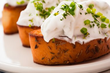 ricotta ve beyaz plaka üzerinde otlar ile dilim tost baget