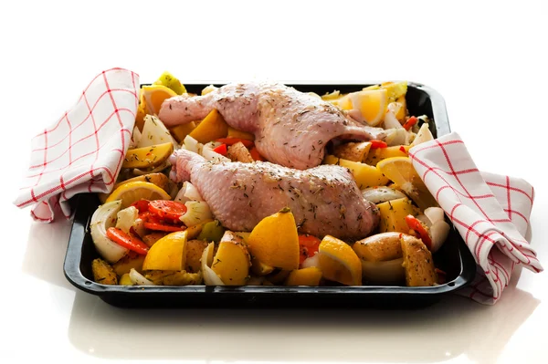 Raw marinated chicken thighs with vegetables on a baking tray — Stock Photo, Image