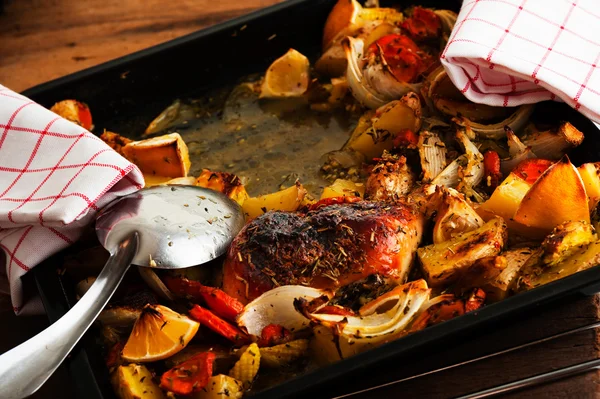 Aked chicken thighs with vegetables on a baking tray — Stock Photo, Image