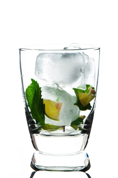 Closeup de vidro com limas de hortelã e cubo de gelo no fundo branco — Fotografia de Stock