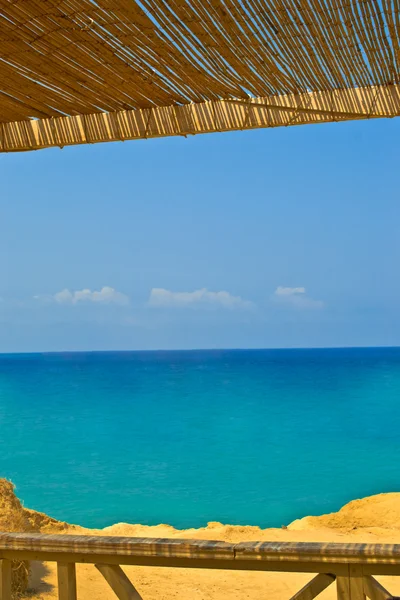 Widok na morze z kawiarnią z trzciny dach — Zdjęcie stockowe