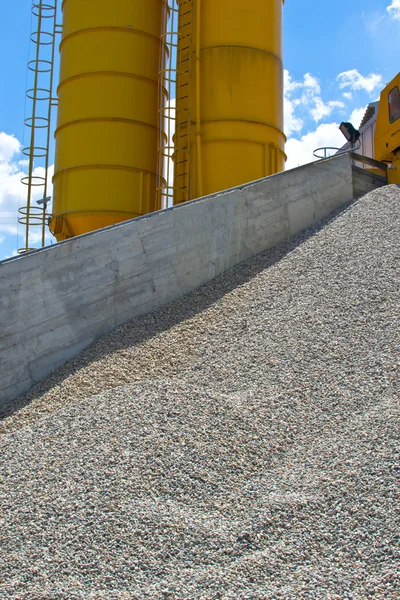 Heaps of granite gravel elimination with yellow silo — Stock Photo, Image