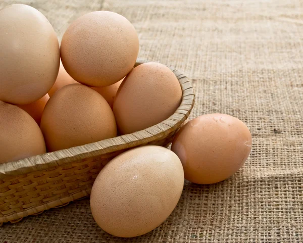 stock image Eggs in a Woven Straw Basket on a burlap Sacking background