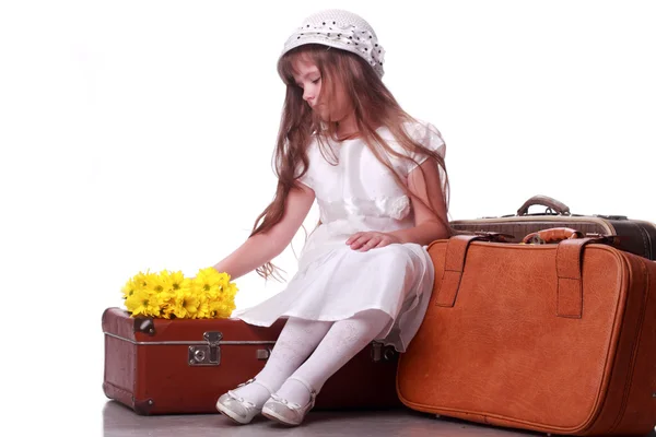 Sad little girl on a suitcase — Stock Photo, Image