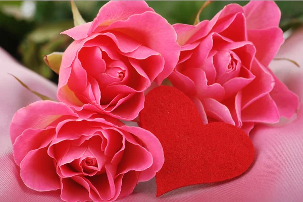 Romántica foto de estudio de tres rosas y un símbolo de corazón para las vacaciones en el tema del Día de San Valentín —  Fotos de Stock