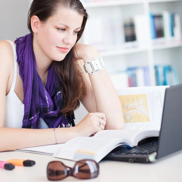 Pretty female college student studying in the university library — Stock Photo, Image
