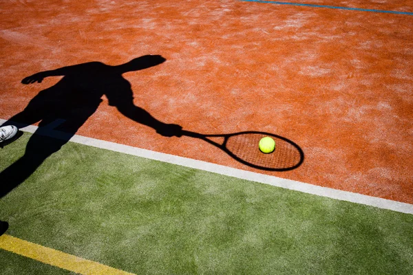 Sombra de un tenista en acción en una cancha de tenis — Foto de Stock
