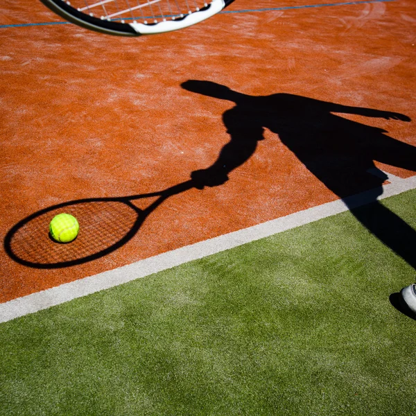 Schatten eines Tennisspielers in Aktion auf einem Tennisplatz — Stockfoto