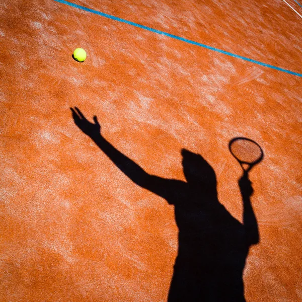 Sombra de um jogador de tênis em ação em um campo de tênis — Fotografia de Stock