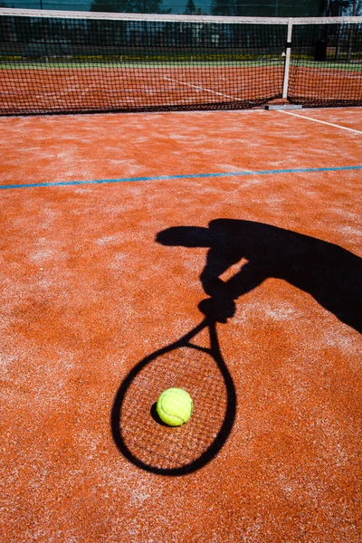 Schatten eines Tennisspielers in Aktion auf einem Tennisplatz — Stockfoto