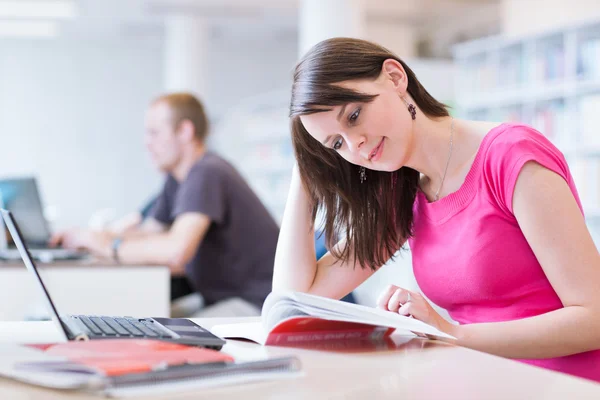 In the library - pretty female student with laptop and books — Stock Photo, Image