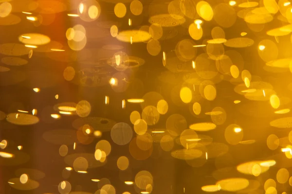 Gyllene makro bakgrund: gas bubblor i öl — Stockfoto