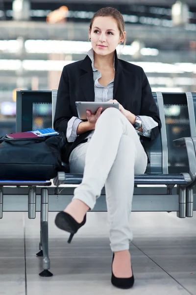 Joven pasajera en el aeropuerto, usando su tableta —  Fotos de Stock