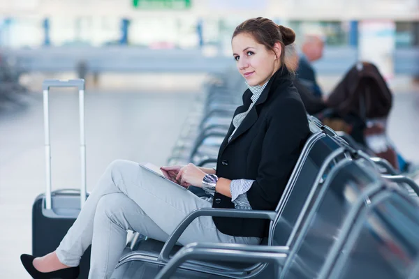 Jovem passageira no aeroporto, usando seu tablet — Fotografia de Stock