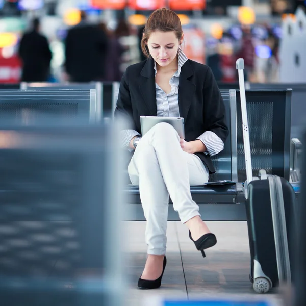 年轻的女乘客在机场使用她的平板电脑 — 图库照片