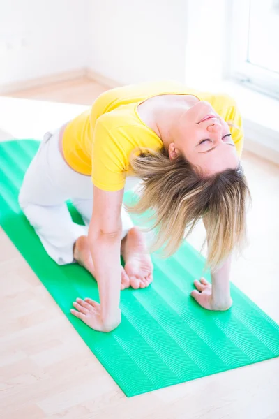 Pretty young woman doing YOGA exercise at home — Stock Photo, Image