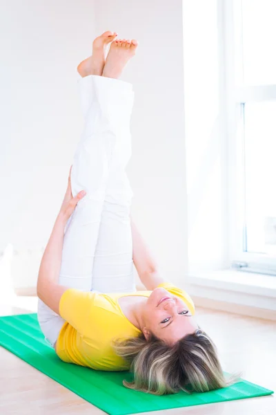 Mooie jonge vrouw doen yoga oefening thuis — Stockfoto
