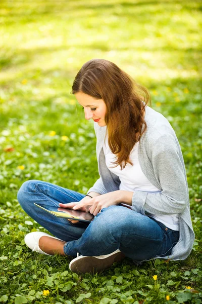 Νεαρή γυναίκα με τον υπολογιστή tablet ενώ χαλαρώνετε σε εξωτερικούς χώρους — Φωτογραφία Αρχείου