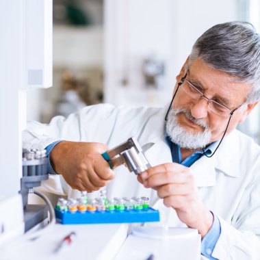 Senior male researcher carrying out scientific research in a lab clipart