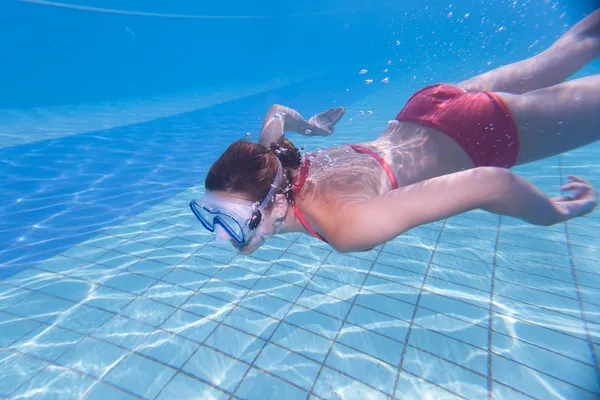 Onderwater zwemmen: jonge vrouw zwemmen onder water in een pool, — Stockfoto