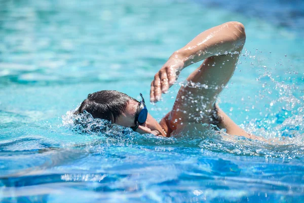Jovem nadando a frente rastejar em uma piscina — Fotografia de Stock