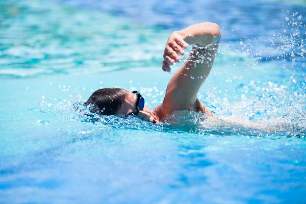 Jovem nadando a frente rastejar em uma piscina — Fotografia de Stock