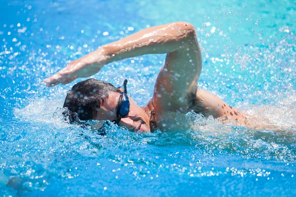 Молодой человек, ползающий впереди в бассейне — стоковое фото