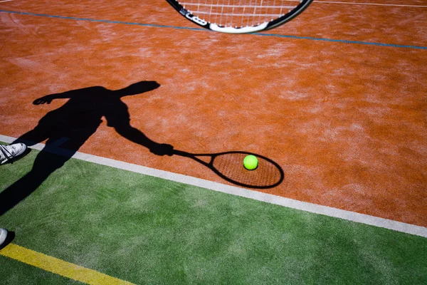 Sombra de un tenista en acción en una cancha de tenis — Foto de Stock