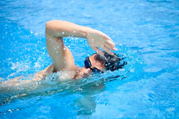 Giovane uomo che nuota davanti strisciare in una piscina — Foto Stock