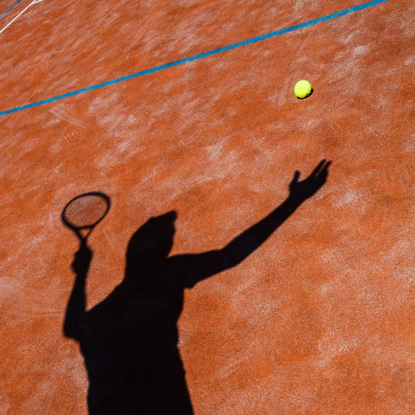 Тень теннисиста в действии на теннисном корте — стоковое фото