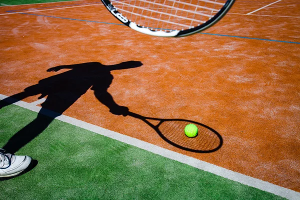 Shadow of a tennis player in action on a tennis court — Stock Photo, Image