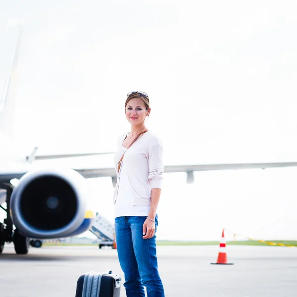 Только что прибыл: молодая женщина в аэропорту, только что покинувшая воздух — стоковое фото