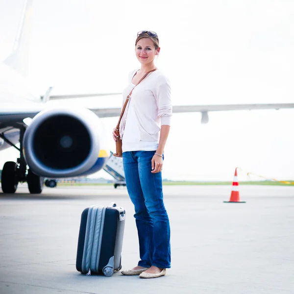Net aangekomen: jonge vrouw bij een luchthaven die net de lucht — Stockfoto