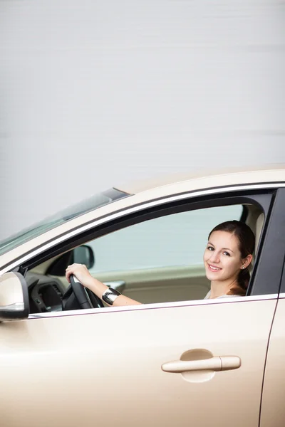 Красивая молодая женщина за рулем своей новой машины — стоковое фото