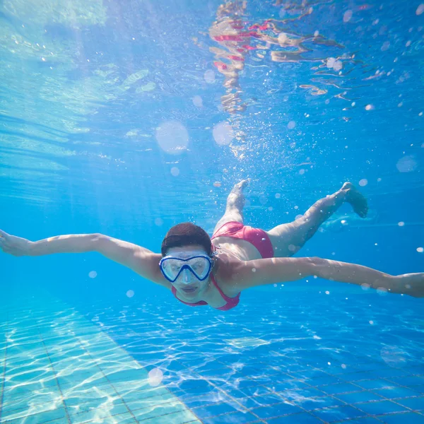Natação subaquática: jovem nadando debaixo d 'água em uma piscina — Fotografia de Stock