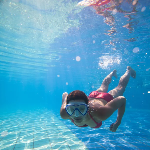 Onderwater zwemmen: jonge vrouw zwemmen onder water in een pool — Stockfoto
