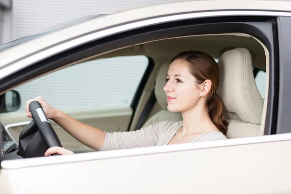 Pretty young woman driving her new car Stock Image