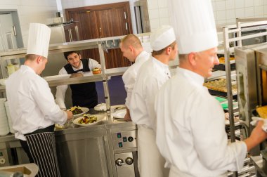 Group of cooks in professional kitchen clipart