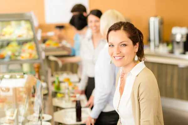 Деловая женщина обедает в кафетерии улыбаясь — стоковое фото