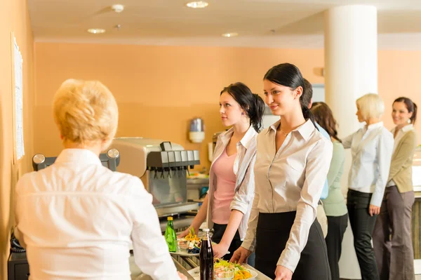 Cafetaria paga em mulheres caixa em fila — Fotografia de Stock