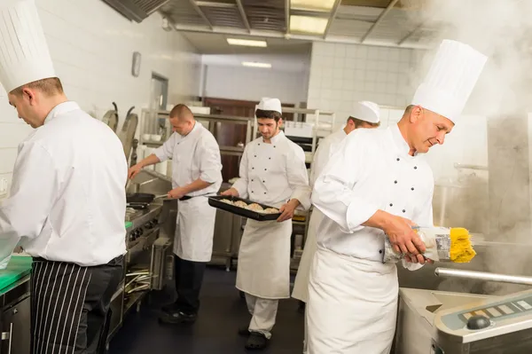 Profesionální kuchyně zaneprázdněn tým kuchařů a kuchař — Stockfoto