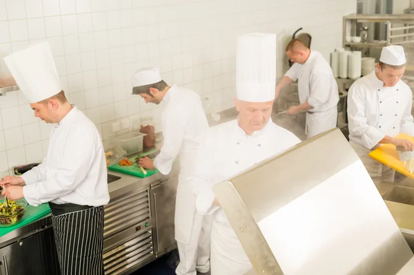 Cozinha profissional equipe ocupada cozinheiros e chef — Fotografia de Stock