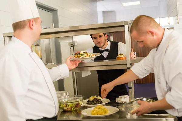 Professionella kök cook förbereda måltid ger servitör — Stockfoto