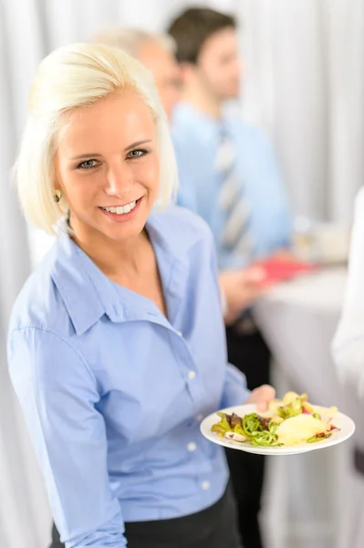 Glimlachende zakenvrouw tijdens bedrijf lunchbuffet — Stockfoto