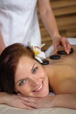 Lava stone massage woman at luxury spa clipart